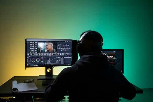 Free A Man Sitting on Front of the Computer while Editing Video Stock Photo