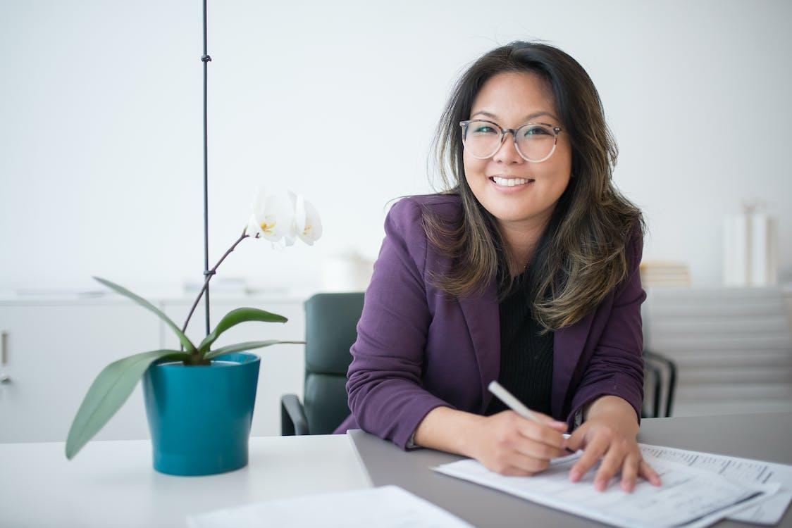 Free A Woman Sitting on a Table with Potted Plant Stock Photo